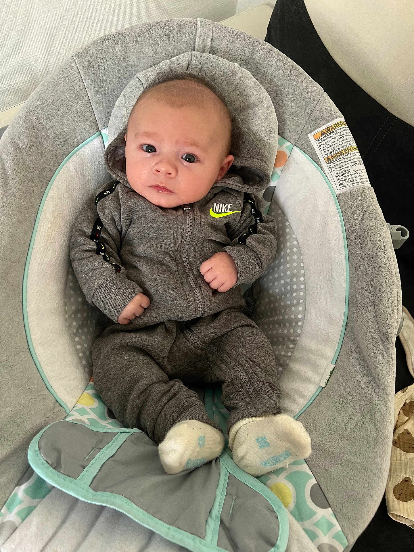 Kayden participe au concours pour gagner de l'argent avec cette photo : baby, infant, newborn, nike_logo, hoodie, gray_clothing, baby_seat, bouncer, cushion, socks, cute, portrait, indoor, soft_texture, eyes, hands, blanket, calm, lifestyle, nursery