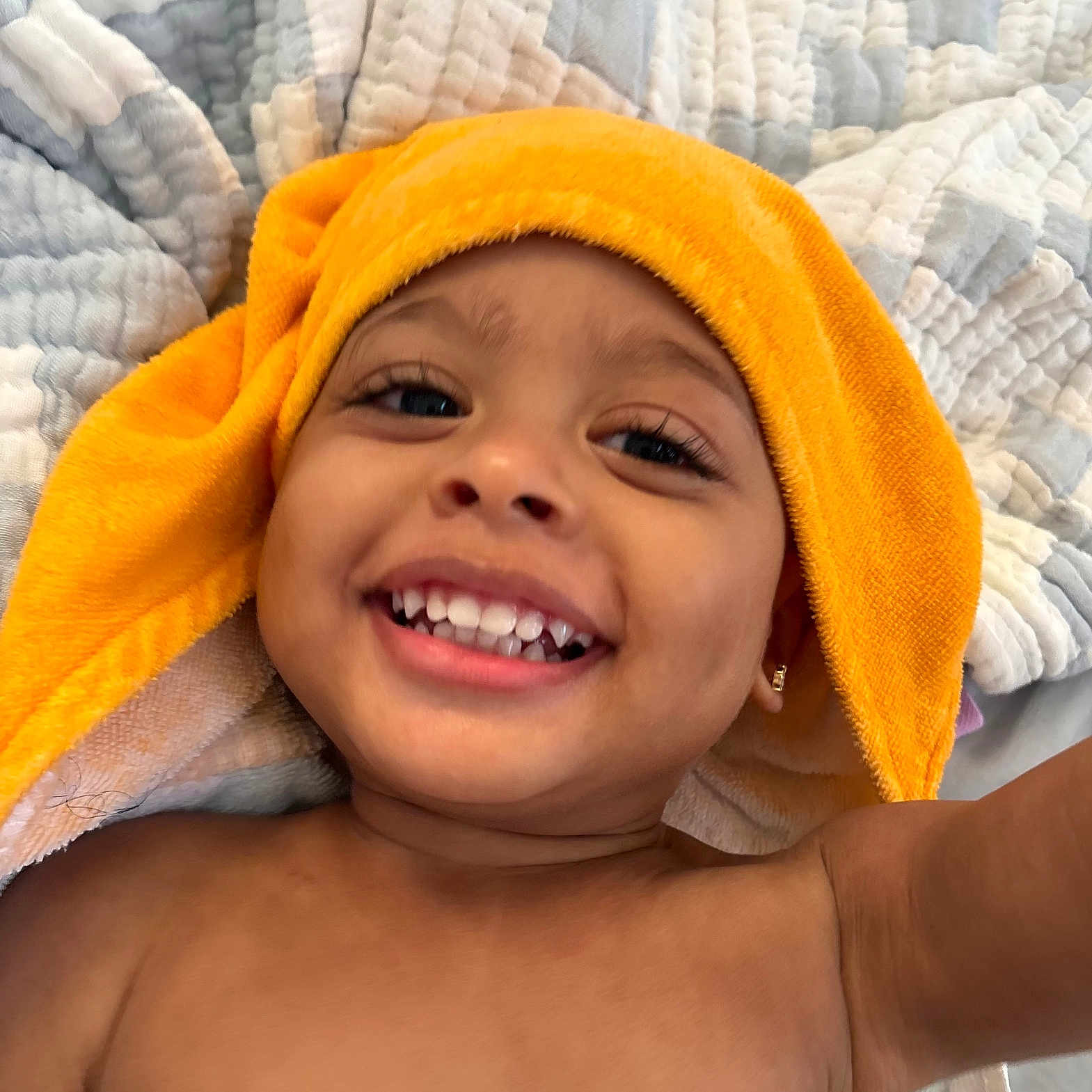 Saheim is registered to the contest to win money with this photo: toddler, child, smile, happy, face, teeth, orange_towel, blanket, quilt, skin, bare_chest, earring, closeup, portrait, indoor, cute, baby, expression, joy, relaxation