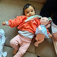 Aleyna participe au concours pour gagner de l'argent avec cette photo : baby, child, plush_toy, couch, clothing, pink_pants, coral_sweatshirt, soft_toy, hand, indoor, cute, face, person, relaxing, comfort, furniture, holding, smiling, toy, infant