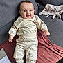 Sacha participe au concours pour gagner de l'argent avec cette photo : baby, infant, smile, happy, couch, sofa, blanket, plush_toy, pacifier, slippers, cream_clothing, pants, sweatshirt, portrait, indoors, relaxed, chubby_cheeks, blue_eyes, hand, furniture