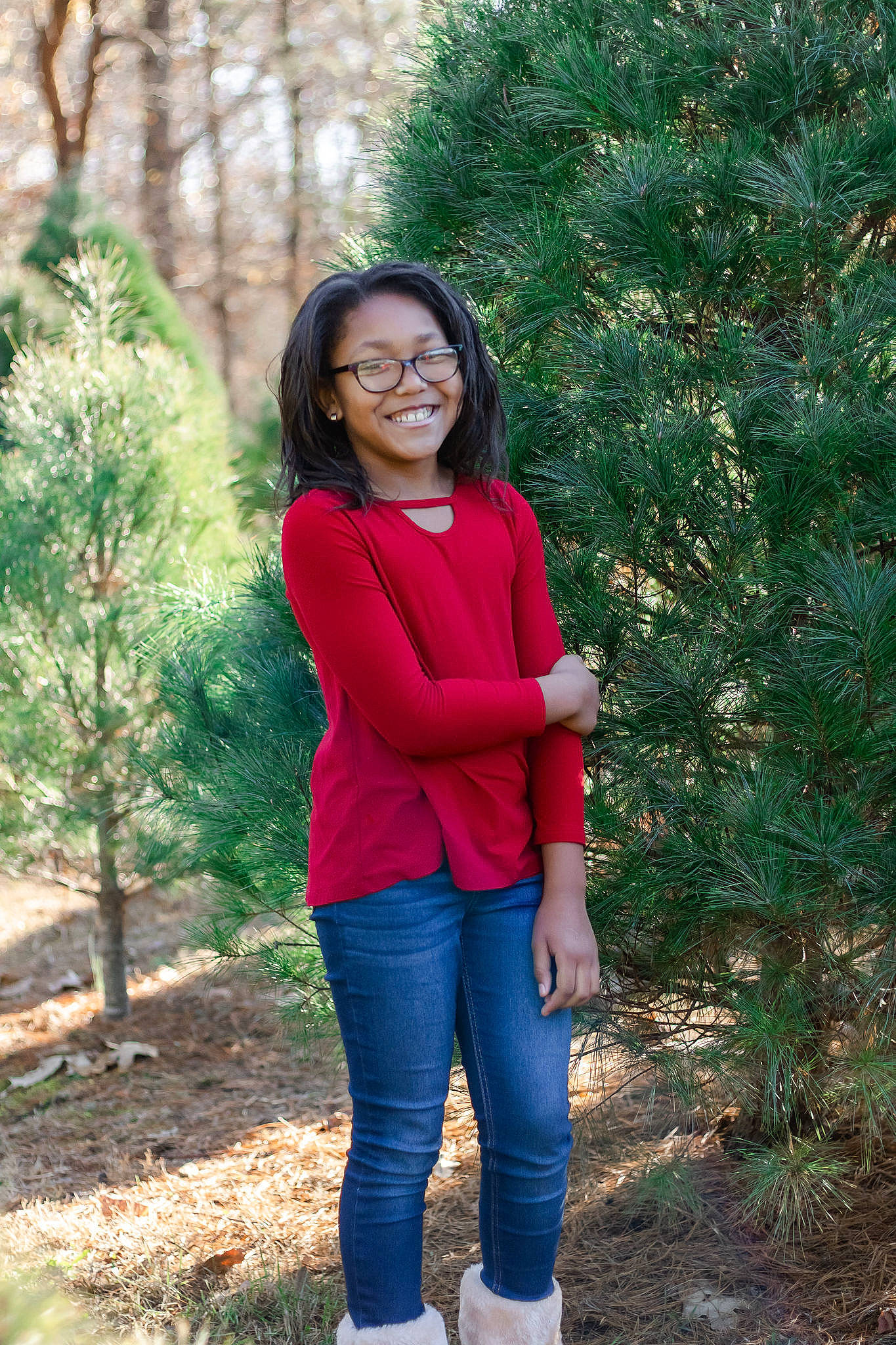 Paris is registered to the contest to win money with this photo: brown_hair, conifer, denim, electric_blue, forest, fur, grass, happy, joy, leisure, long_hair, magenta, people_in_nature, person, plant, sitting, sleeve, smile, tree, trunk