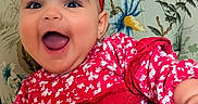 Ellyana joined the competition — help win amazing prizes! baby, child, smiling, happy, red_bow, red_dress, floral_pattern, chair, portrait, cute, indoors, person, headwear, toddler, sitting, bright_colors, joyful, cute_expression, fashion, closeup