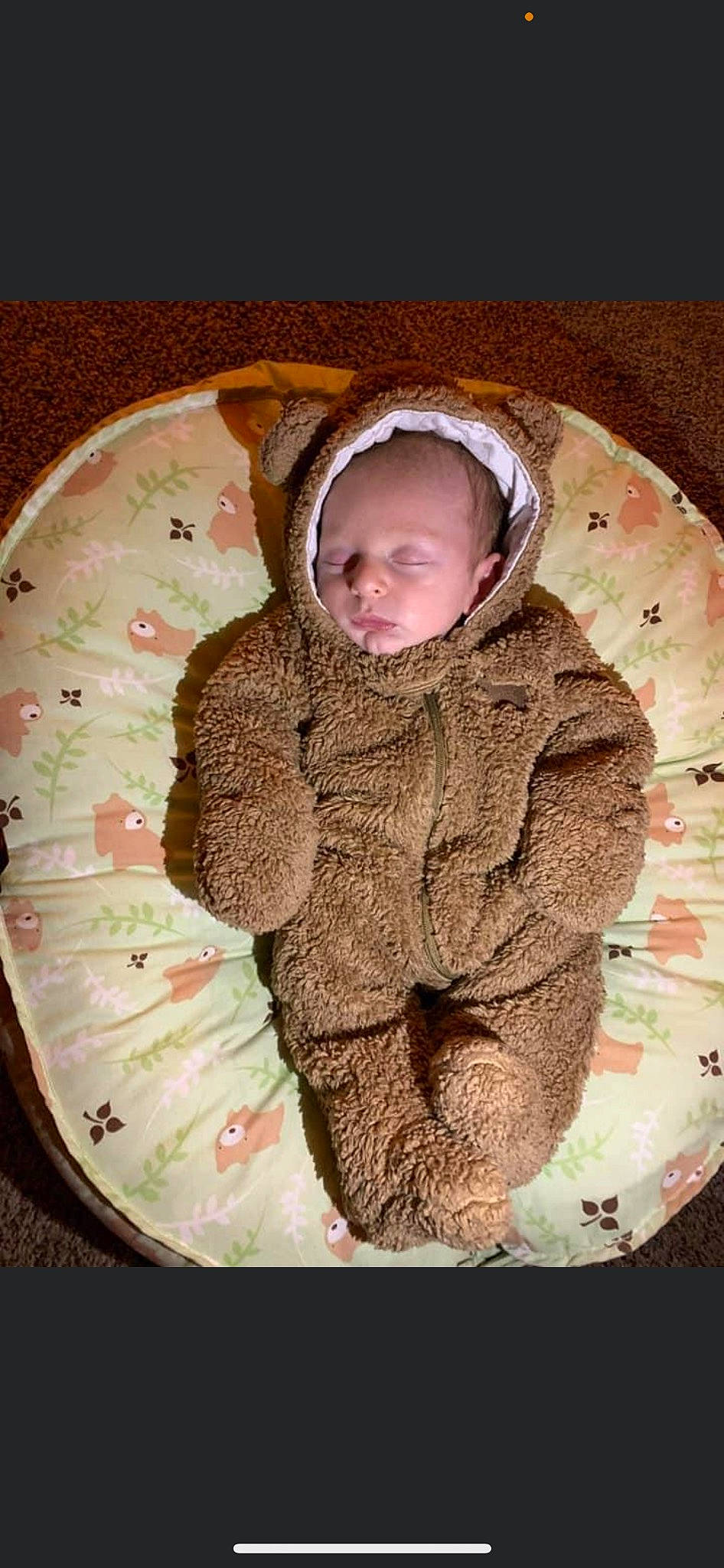 Broc is registered to the contest to win money with this photo: baby, camouflage, cap, child, circle, comfort, fur, grass, hood, hoodie, linens, military_camouflage, outerwear, pattern, person, personal_protective_equipment, sleeve, toddler, wood, wool