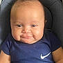 baby, infant, smile, face, blue_clothing, nike_logo, mohawk_hair, cushion, baby_seat, child, cute, portrait, chubby_cheeks, happy, young, skin, person, indoor, apparel, head