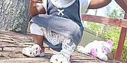 Amiri is registered to the contest to win money with this photo: casual, child, clothing, crouching, daylight, footwear, happy, nature, outdoor, person, playground, smile, snack, stuffed_animal, sunlight, toddler, toy, tree, wood, wooden_structure