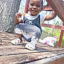 casual, child, clothing, crouching, daylight, footwear, happy, nature, outdoor, person, playground, smile, snack, stuffed_animal, sunlight, toddler, toy, tree, wood, wooden_structure