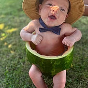 Nico joined the competition — help win amazing prizes! baby, watermelon, hat, bow_tie, outdoor, grass, happy, smiling, child, fruit, summer, cute, playful, nature, skin, barefoot, fun, green, headwear, portrait