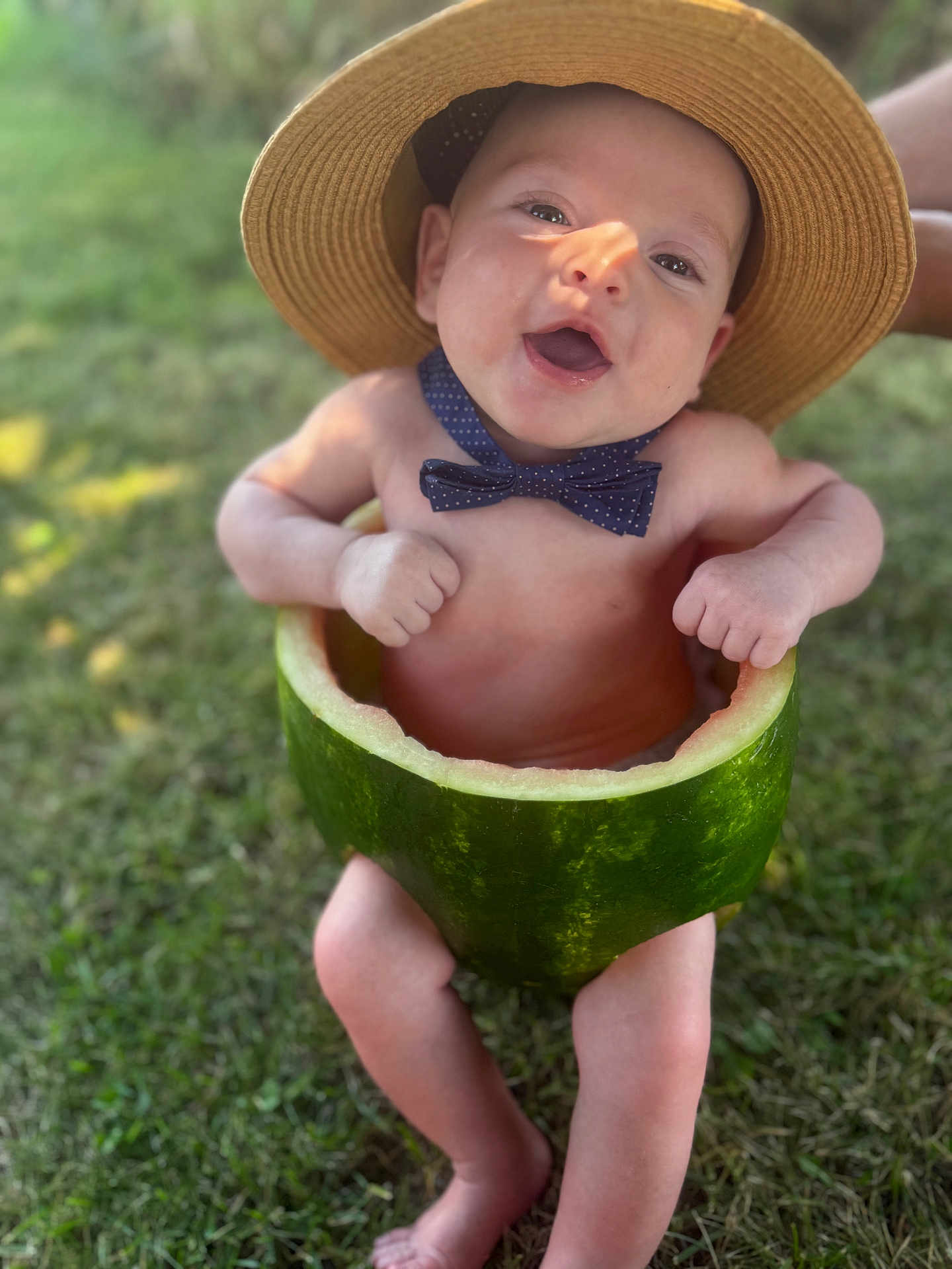 Nico joined the competition — help win amazing prizes! baby, watermelon, hat, bow_tie, outdoor, grass, happy, smiling, child, fruit, summer, cute, playful, nature, skin, barefoot, fun, green, headwear, portrait
