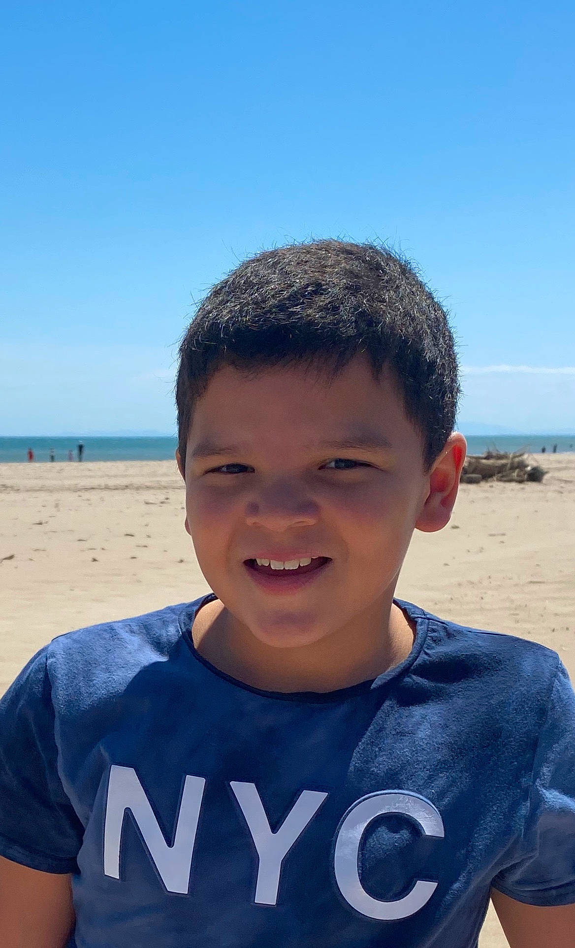 Theo participe au concours pour gagner de l'argent avec cette photo : beach, child, chin, facial_expression, forehead, hairstyle, happy, jaw, joy, ocean, person, sand, sea, smile, summer, vacation