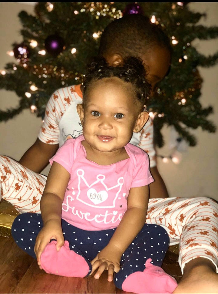 Bralyn is registered to the contest to win money with this photo: child, christmas, christmas_decoration, christmas_eve, christmas_ornament, christmas_tree, daughter, event, fir, happy, holiday, interior_design, joy, person, pink, play, sitting, smile, toddler, tree
