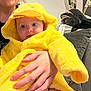 Adalynn joined the competition — help win amazing prizes! baby, child, costume, yellow, duck, hooded, towel, cute, indoor, person, hand, cushion, furniture, blue_eyes, clothing, adult, holding, infant, portrait, expression