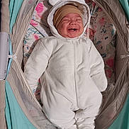 Michael joined the competition — help win amazing prizes! baby, infant, onesie, white_clothing, smiling, bassinet, baby_bed, floral_pattern, headwear, brown_hat, cute, cozy, sleepwear, footed_pajamas, child, happy, indoors, soft_toys, baby_accessories, portrait