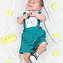 Michael joined the competition — help win amazing prizes! baby, infant, smile, suspenders, sneakers, blanket, knit, yellow, marshmallow, toy, cute, child, happy, lying_down, patterned_shirt, feet, playful, soft_texture, indoors, portrait