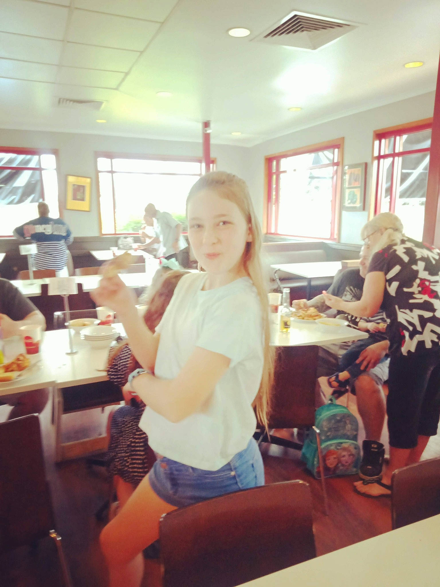 Anneliese is registered to the contest to win money with this photo: blurred, ceiling, chair, child, class, education, event, fun, job, learning, leisure, person, recreation, room, school, service, shorts, t_shirt, table, teacher