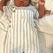 Ozar joined the competition — help win amazing prizes! baby, child, infant, portrait, lying_down, bed, bedding, blanket, patterned_background, striped_clothing, overalls, cap, hat, shoes, socks, fashion, adorable, looking_at_camera, indoor, smiling