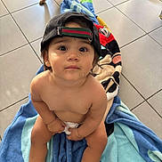 Harmonie participe au concours pour gagner de l'argent avec cette photo : toddler, child, hat, cap, floor, tile, towel, dog, barefoot, footwear, indoor, cute, looking_up, sitting, curious, wide_eyes, skin, person, animal, casual