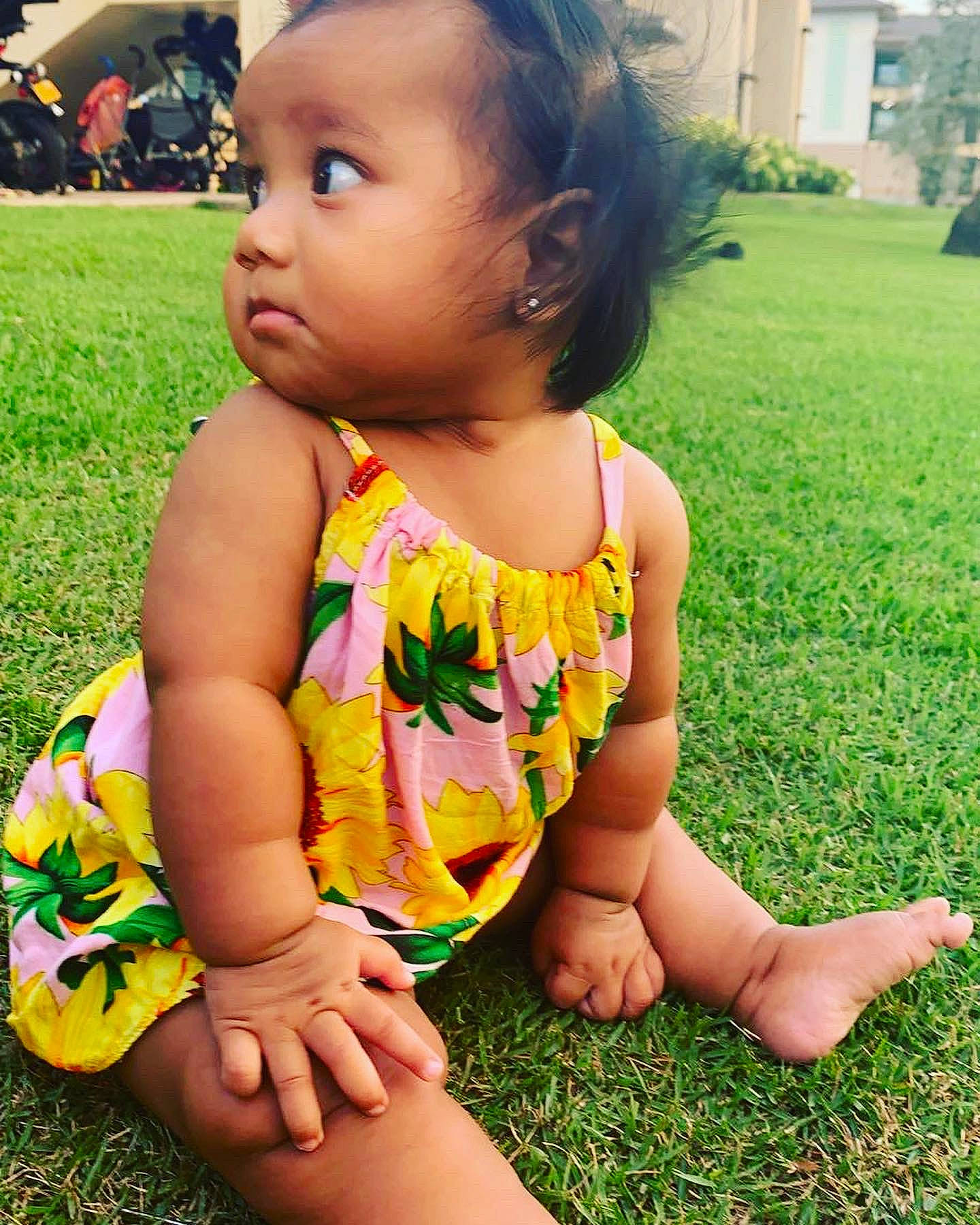 Deborah is registered to the contest to win money with this photo: baby_toddler_clothing, dress, eye, face, facial_expression, green, hair, hand, happy, head, human_body, leaf, light, nose, people_in_nature, person, photograph, plant, skin, sunlight