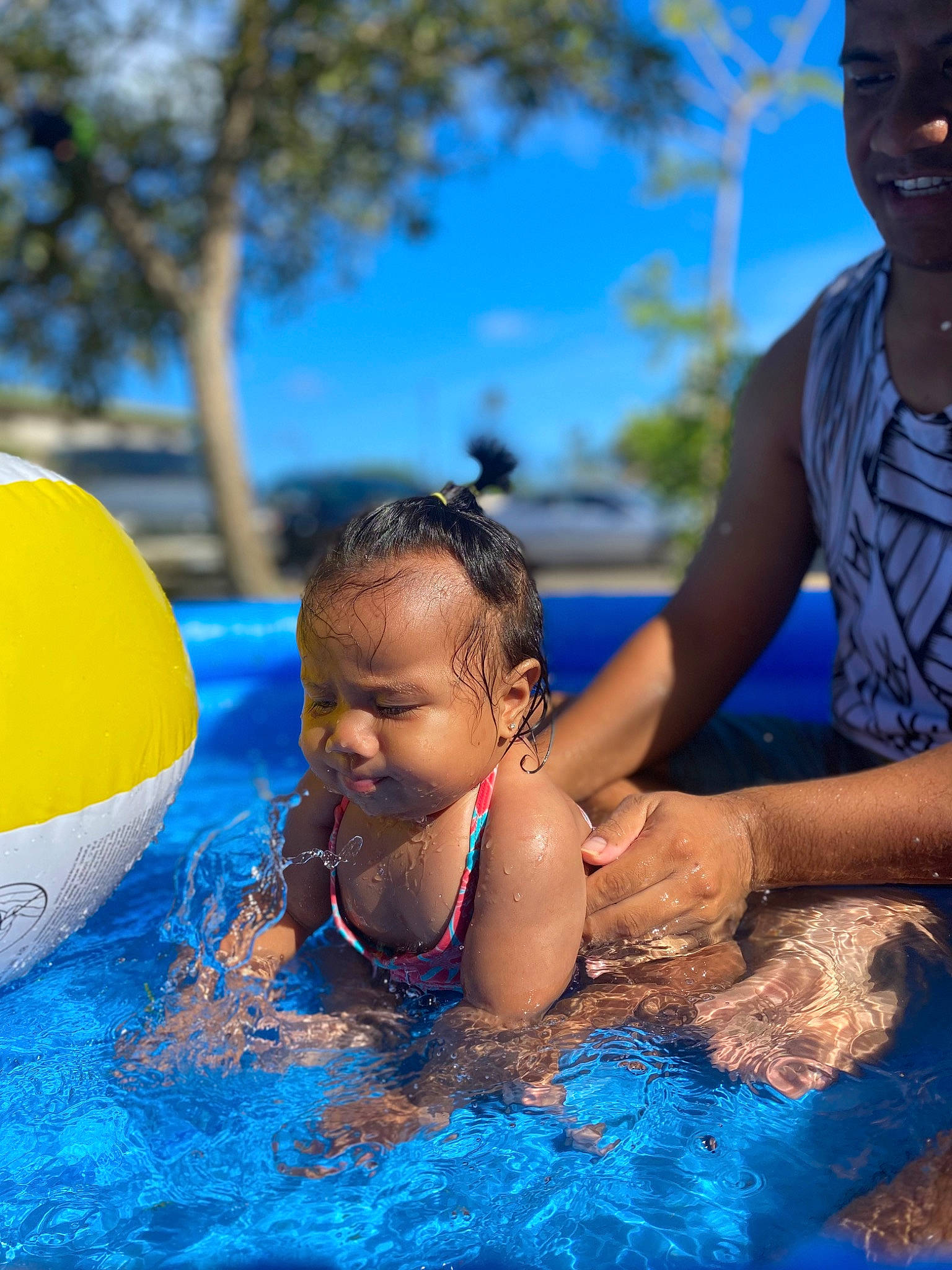 Deborah is registered to the contest to win money with this photo: azure, baby, bathing, blue, child, event, face, fun, happy, leisure, person, recreation, sky, smile, summer, swimming_pool, swimwear, toddler, tree, vacation