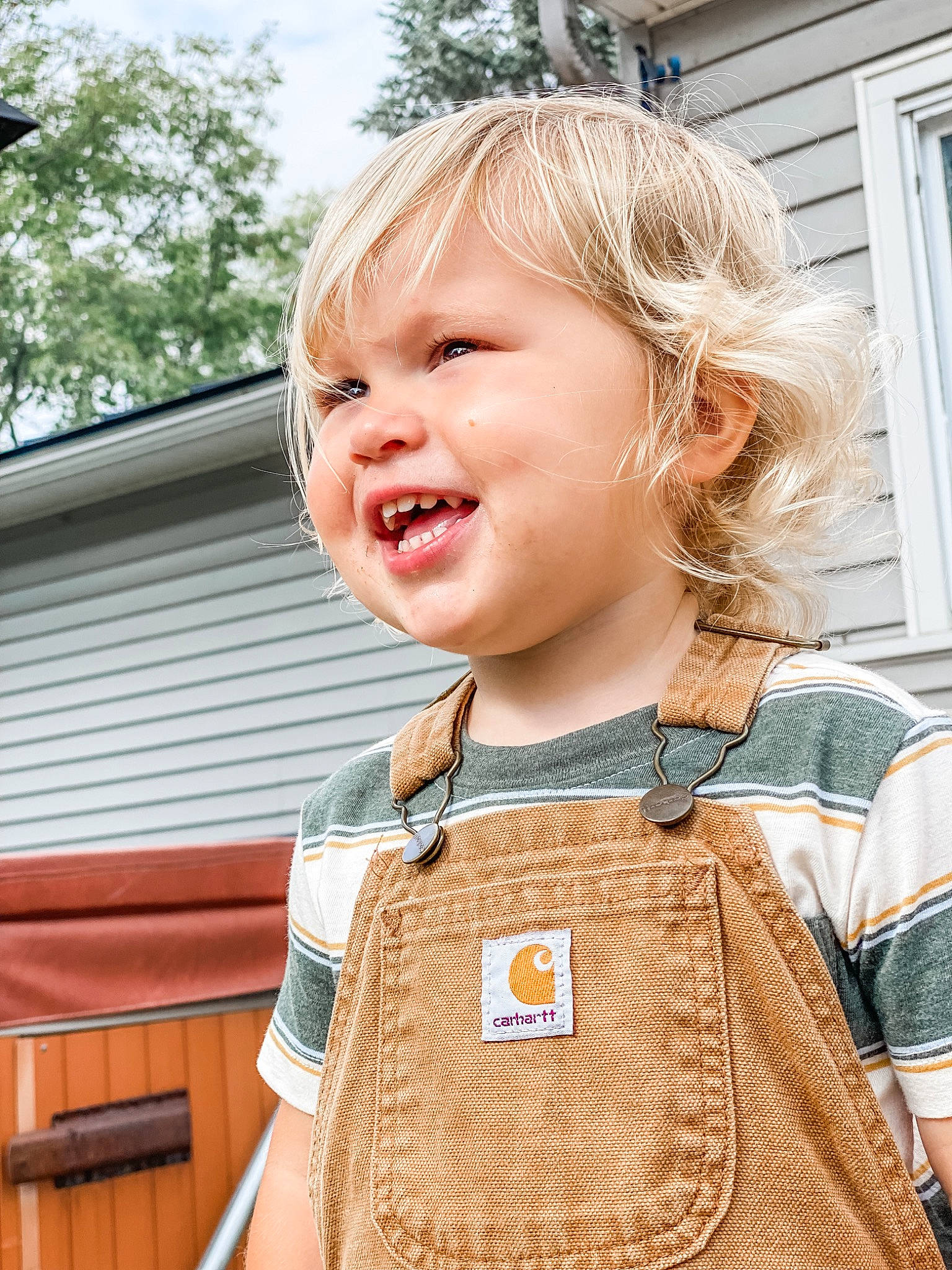 Landon is registered to the contest to win money with this photo: blond, child, daytime, electric_blue, eye, fashion_accessory, fun, hair, happy, head, iris, jewellery, leisure, person, sleeve, smile, street_fashion, t_shirt, toddler, travel