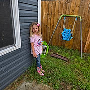 Courtney joined the competition — help win amazing prizes! backyard, blue_swing, casual_clothing, child, concrete, daylight, girl, grass, house_wall, jeans, outdoor, pink_boots, pink_bow, pink_shirt, playground, standing, swing, toy, window, wooden_fence