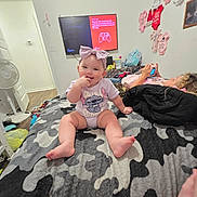 Amelia Stanberry joined the competition — help win amazing prizes! baby, child, bow, bed, blanket, camouflage, clothing, device, furniture, game_console, headband, indoor, person, playing, room, screen, smiling, technology, toddler, wall