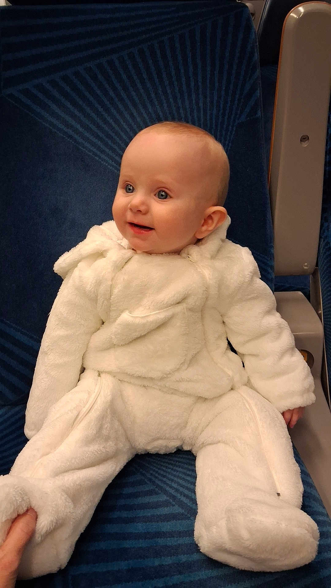 London a rejoint le concours — aidez-le/la à gagner de superbes lots ! baby, child, infant, onesie, white_clothing, seat, blue_seat, happy, smiling, face, hand, cozy, cute, indoor, portrait, sitting, warm_clothing, young_child, fur_texture, comfortable