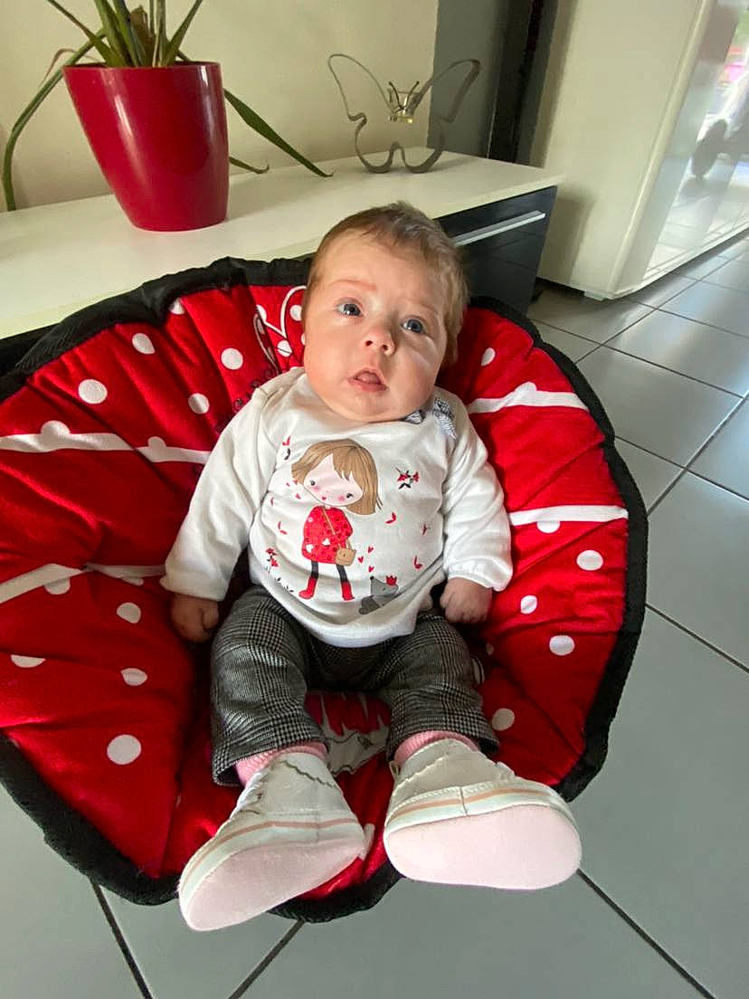 Oxana a rejoint le concours — aidez-le/la à gagner de superbes lots ! baby, baby_toddler_clothing, carmine, child, comfort, floor, flooring, flowerpot, holiday, houseplant, living_room, pattern, person, plant, red, room, sitting, sleeve, sock, toddler