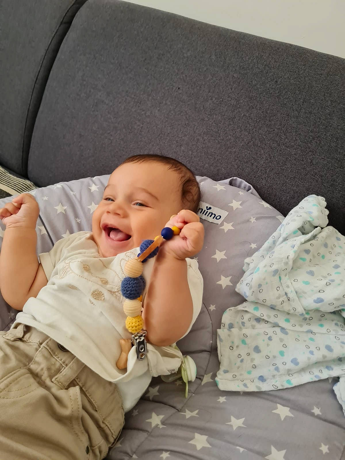 Aydan a rejoint le concours — aidez-le/la à gagner de superbes lots ! baby, baby_laughing, baby_products, baby_toddler_clothing, bed, bedding, child, comfort, couch, gesture, hairstyle, happy, laugh, linens, person, pillow, room, sitting, smile, throw_pillow