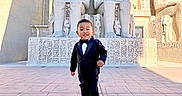 Patrick is registered to the contest to win money with this photo: ancient, architecture, boy, carved, child, culture, egyptian, hieroglyphics, historical, monument, outdoor, shadow, smiling, sneakers, statues, stone, sunlight, tourist, tuxedo, walking
