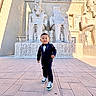 ancient, architecture, boy, carved, child, culture, egyptian, hieroglyphics, historical, monument, outdoor, shadow, smiling, sneakers, statues, stone, sunlight, tourist, tuxedo, walking