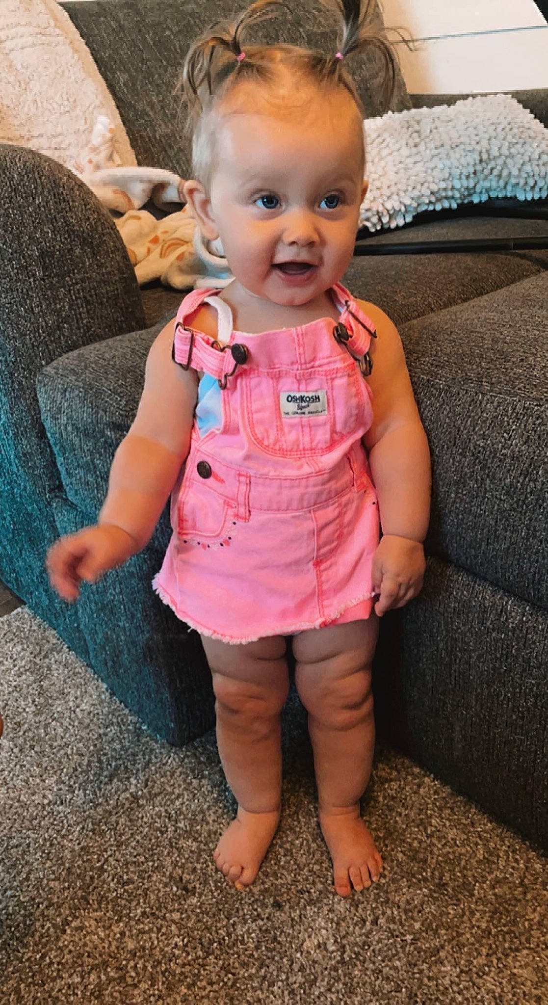 Reese is registered to the contest to win money with this photo: baby, baby_toddler_clothing, cheek, child, couch, eye, eyebrow, eyelash, face, finger, gesture, happy, lip, nose, person, pink, skin, sleeve, smile, surprise