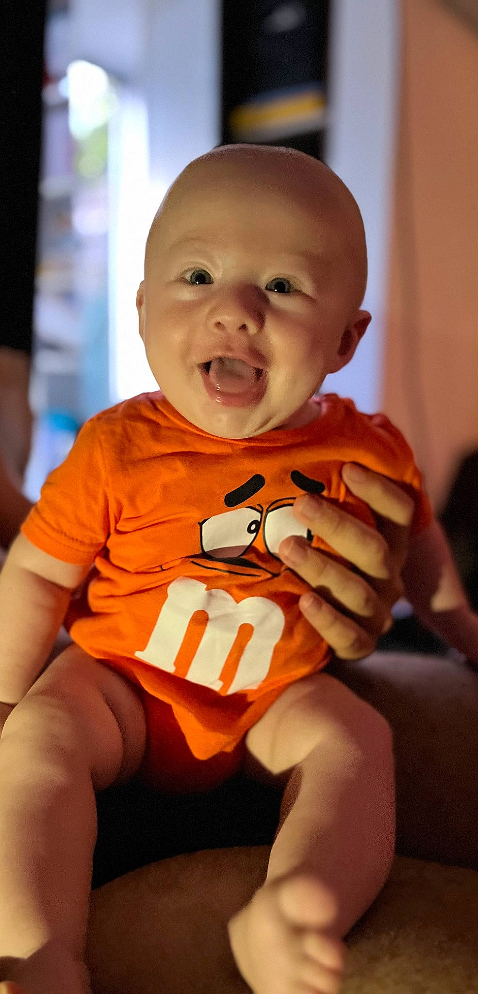 Johan participe au concours pour gagner de l'argent avec cette photo : baby, baby_toddler_clothing, carmine, cheek, child, elbow, finger, fun, happy, laugh, nail, orange, person, room, sitting, skin, sleeve, smile, t_shirt, thigh