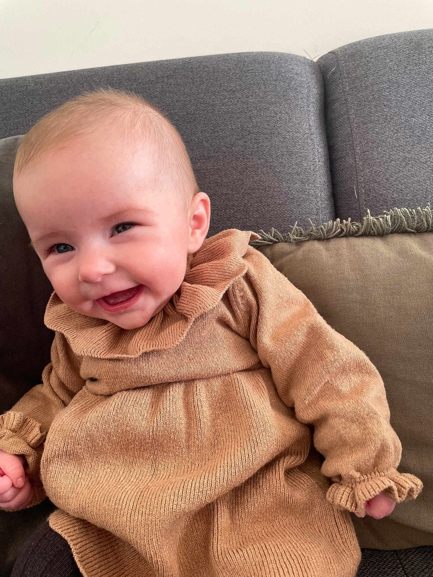Luna participe au concours pour gagner de l'argent avec cette photo : baby, smiling, child, sweater, tan, cozy, couch, pillow, indoor, happy, cute, portrait, infant, knitwear, furniture, young_child, warm, face, person, seated