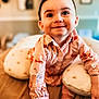 baby, bed, child, cute, eyes, face, hair, happy, home, indoors, infant, patterned_clothing, person, pillow, portrait, shirt, skin, smiling, toddler, young_child
