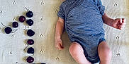Gabriel participe au concours pour gagner de l'argent avec cette photo : baby, infant, striped_onesie, knitted_blanket, cherries, number_one, embroidery, name, lying_down, newborn, cute, celebration, fruit, small_hands, small_feet, portrait, indoor, soft_texture, peaceful, child