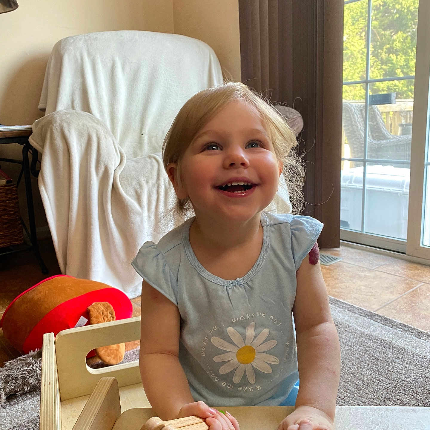 Isabella is registered to the contest to win money with this photo: architecture, building, child, clothing, electronics, face, female, furniture, girl, head, indoors, livingroom, person, phone, photography, portrait, room, sitting, t_shirt, wood
