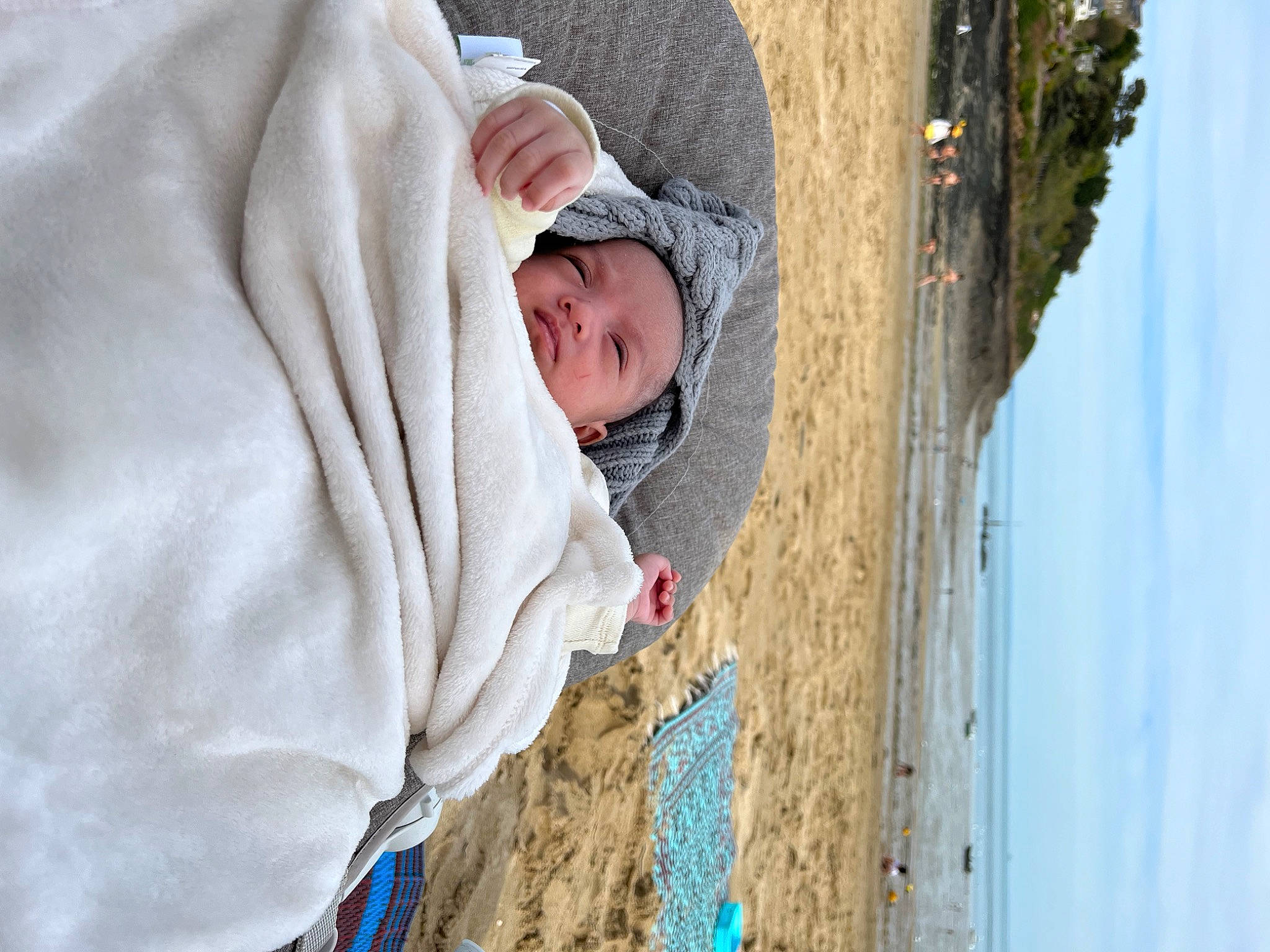 Linoulia participe au concours pour gagner de l'argent avec cette photo : baby, beach, cap, child, concrete, fun, hat, headwear, hood, hoodie, landscape, leisure, person, recreation, rock, sitting, sky, toddler, tree, vacation