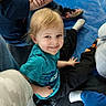 Leilani is registered to the contest to win money with this photo: blond_hair, blue_shirt, candid, casual_clothing, child, feet, floor, group, happy, indoor, jeans, legs, person, play_mat, playtime, sitting, smiling, sneakers, socks, young_child