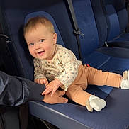 Romy participe au concours pour gagner de l'argent avec cette photo : baby, child, smiling, blue_seat, vehicle_interior, hand, clothing, socks, seatbelt, playful, person, infant, happy, cute, indoor, transport, seat, holding_hand, casual, joy