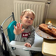 Nahël a rejoint le concours — aidez-le/la à gagner de superbes lots ! birthday, birthday_candle, cake, celebration, chair, child, face, food, hand, high_chair, indoor, levis, party, radiator, smiling, sweatshirt, table, toddler, waving, young_child