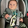 Illan a rejoint le concours — aidez-le/la à gagner de superbes lots ! baby, car_seat, pacifier, pacifier_clip, green_clothing, infant, child, straps, seat_belt, close_up, indoor, person, cute, face, hand, blue_eyes, soft_fabric, sitting, comfortable, young_child