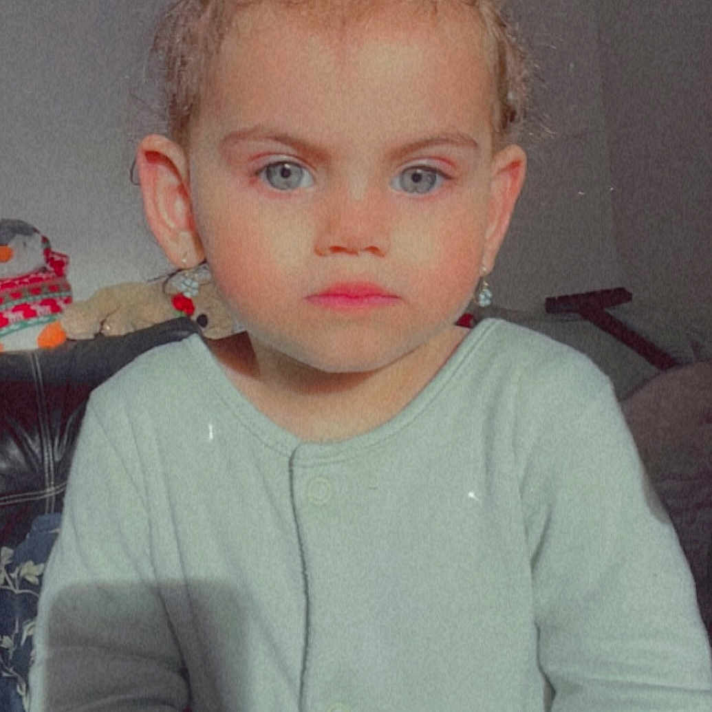 Emily is registered to the contest to win money with this photo: accessories, baby, blonde, clothing, couch, face, frown, furniture, hair, head, knitwear, longsleeve, mohawkhairstyle, person, photography, portrait, sad, sleeve, sweater, t_shirt