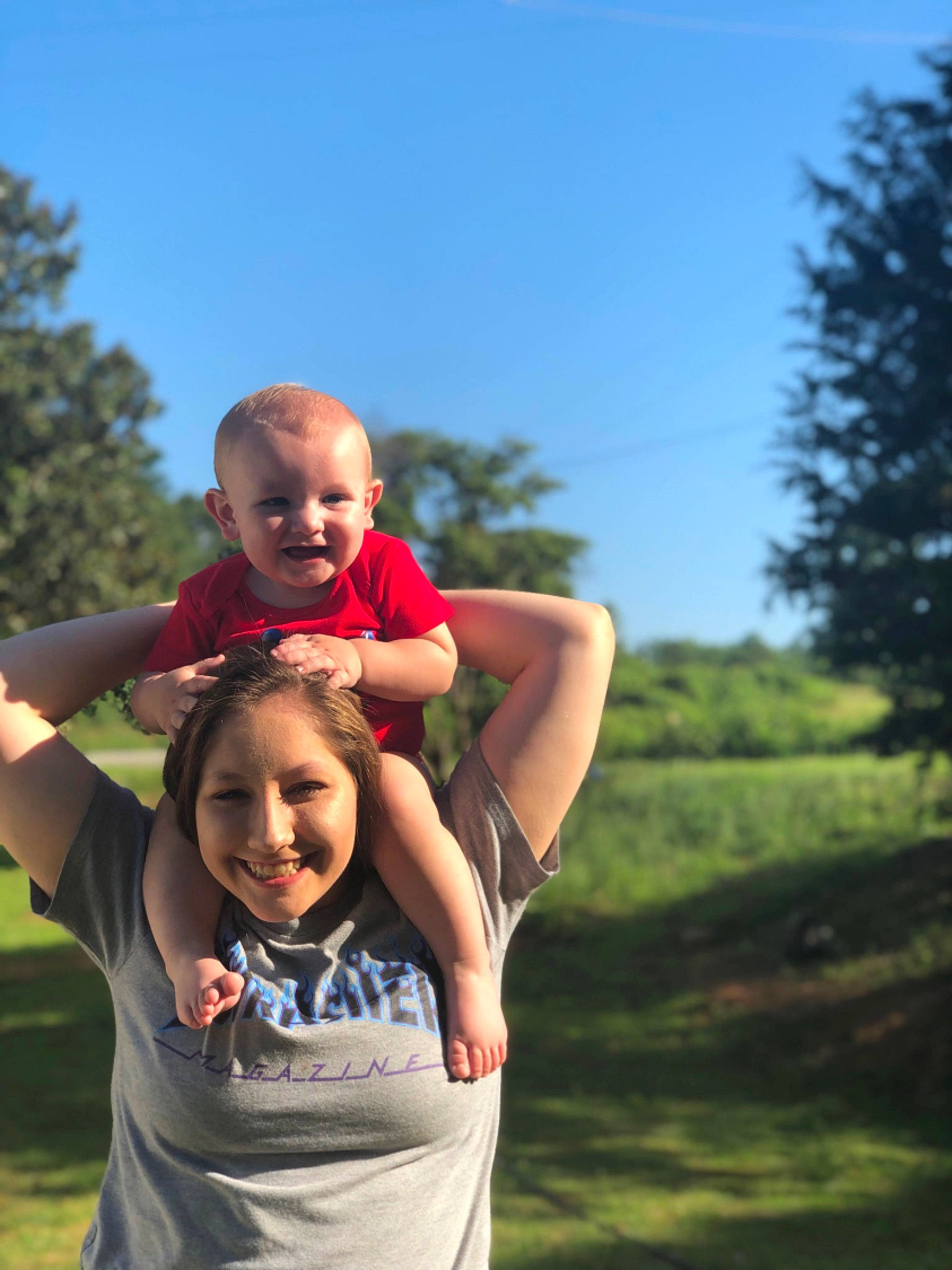 Drayton is registered to the contest to win money with this photo: arm, child, facial_expression, fun, grass, grassland, happy, joint, joy, male, people, people_in_nature, person, photography, red, shoulder, sky, smile, summer, tree