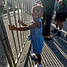 Pheobe joined the competition — help win amazing prizes! amusement_park, braids, child, denim_dress, family, fence, girl, hair_bows, happy, metal_railing, outdoor, people, playground, portrait, shadows, smiling, sneakers, standing, summer, sunlight