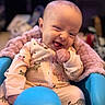 Rowyn joined the competition — help win amazing prizes! baby, infant, onesie, animal_print, blue_seat, pink_blanket, smiling, winking, tongue_out, indoors, blurred_background, bookshelf, cute, child, portrait, happy, cozy, soft_lighting, person, seated