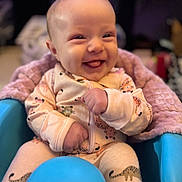 Rowyn joined the competition — help win amazing prizes! baby, smiling, onesie, animal_print, blue_seat, blanket, indoor, happy, infant, cute, portrait, child, cozy, furniture, pink_blanket, comfortable, playful, face, seated, tongue_out