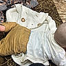 baby, infant, couch, blanket, carpet, clothing, head, back, pattern, fabric, purse, indoors, floor, person, toddler, brown, white, resting, soft, cute