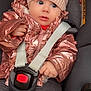 baby, child, car_seat, jacket, hat, knit_hat, seatbelt, straps, infant, clothing, pink, rose_gold, cute, portrait, indoor, safety, wide_eyes, hand, face, person