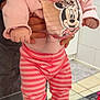 baby, child, person, pink_clothing, striped_pants, slippers, indoor, bib, minnie_mouse, cute, holding, hands, tiles, floor, adult, expression, portrait, footwear, closeup, cozy