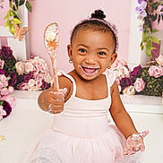 Ny'Ari is registered to the contest to win money with this photo: toddler, child, cake, messy, frosting, pink, dress, smile, happy, sitting, wooden_spoon, flowers, butterfly, celebration, birthday, indoor, cute, playful, portrait, fun